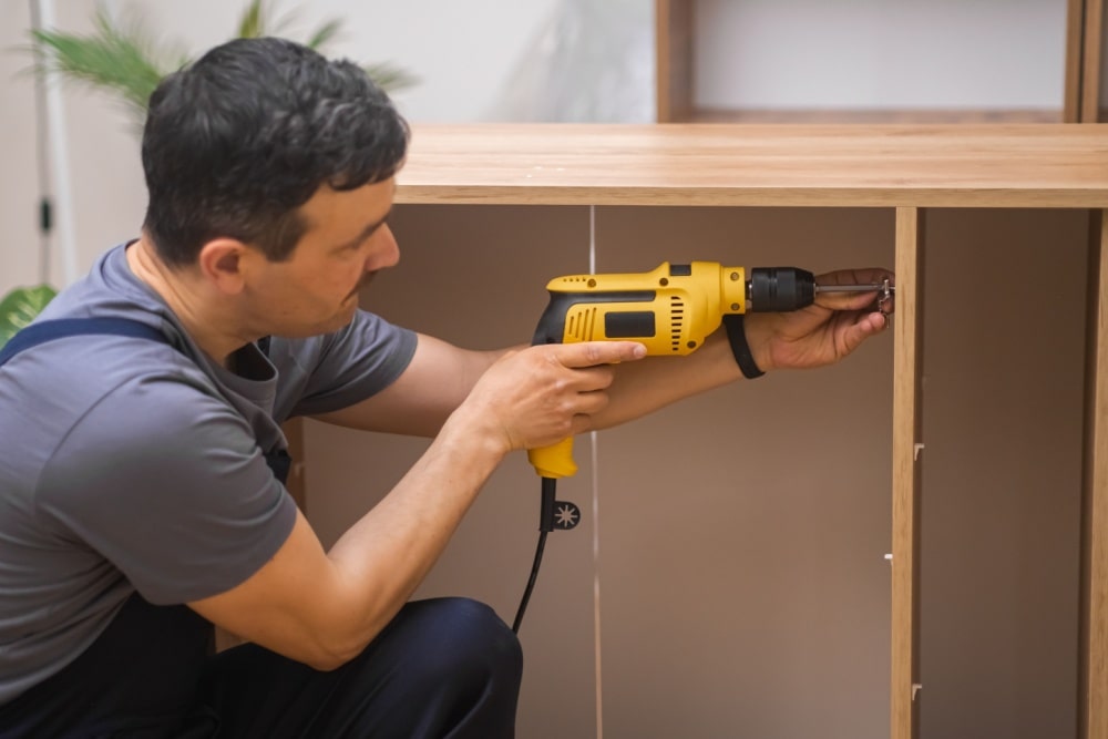 a man assembling an office cabinet