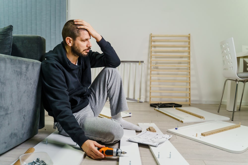 man frustrated from assembling furnitrue
