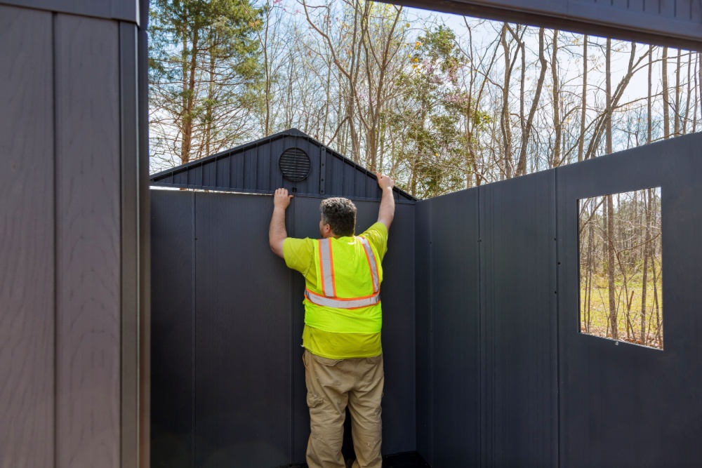 worker assembling storage shed