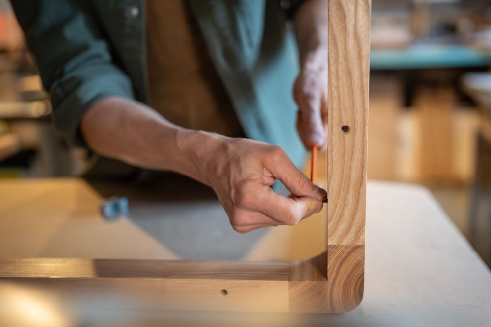 craftsman screwing furniture screws into the table