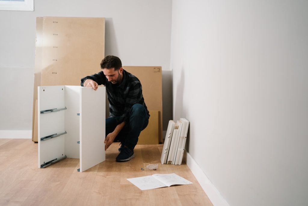 Portrait of young man assembling furniture. Do it yourself furniture assembly in ottawa.
